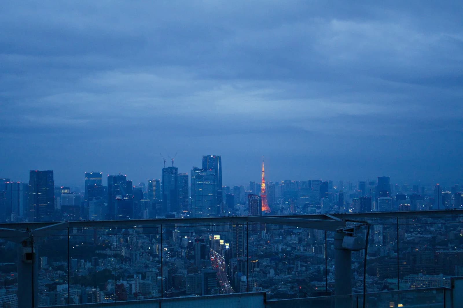 Tokyo Tower lit at dusk above the Tokyo skyline